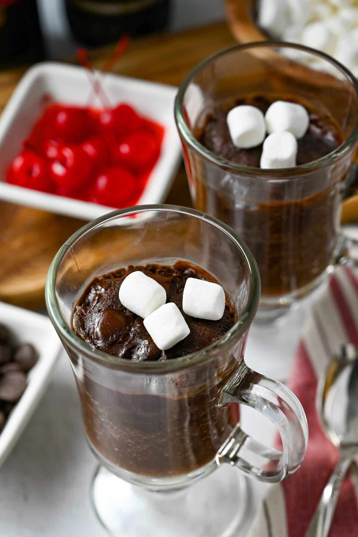 two chocolate mug cakes topped with marshmallows