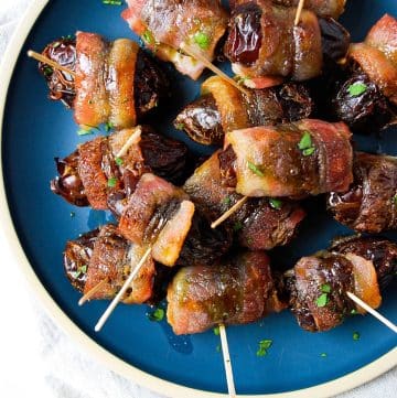 close up photo of bacon wrapped stuffed dates with toothpicks