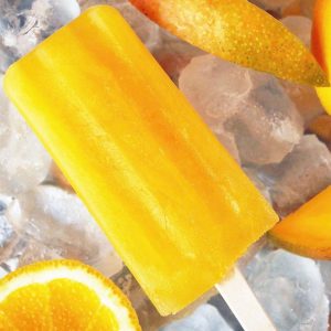 Mango orange popsicle on ice with fruit slices