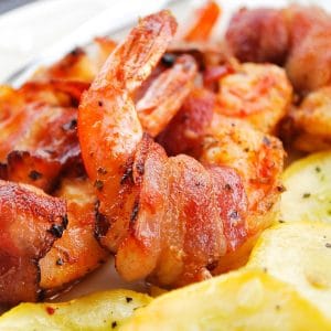 jumbo smoked shrimp wrapped in bacon cooked and plated with yellow squash