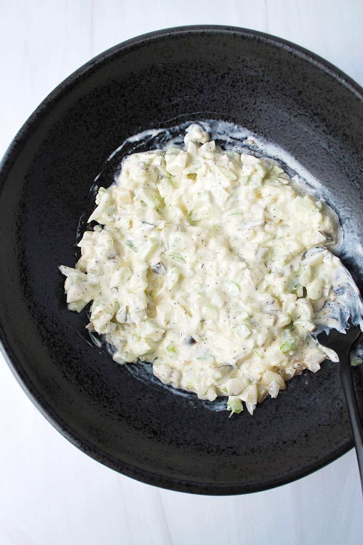 egg salad dressing mixed in a black bowl