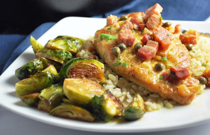 plate of chicken piccata with brussels sprouts and rice