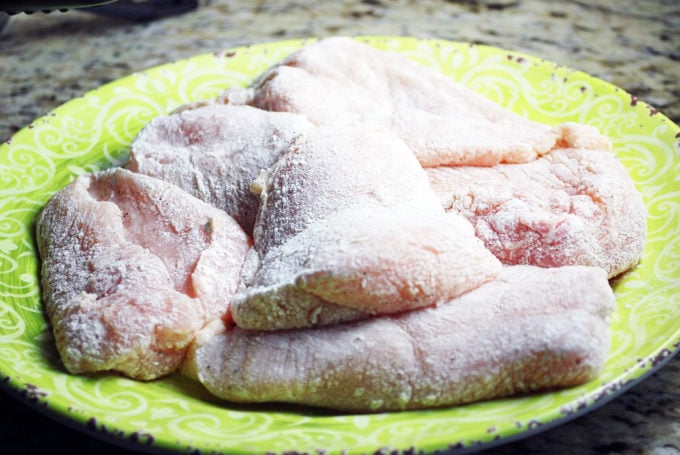 plate of chicken breasts dredged in flour