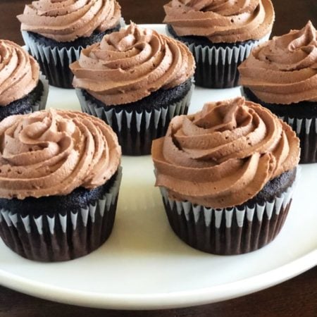 Side view of chocolate cupcakes on a white platter