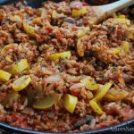 Pork and brown rice skillet cooked with a spoon