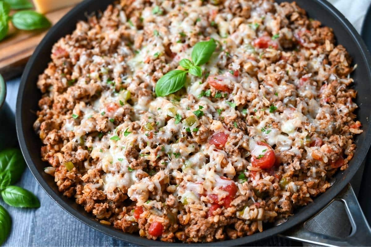 side view of a skillet meal made with ground beef, Italian pork sausage, tomatoes, spices, and cheese