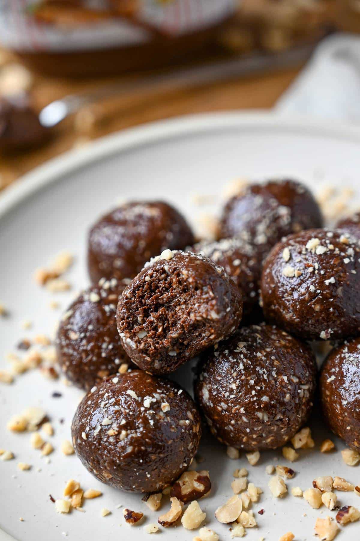 chocolate nutella protein balls on a plate with chopped hazelnuts