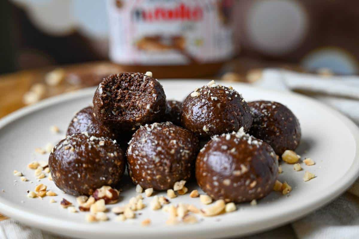 a plate of nutella balls with a jar of nutella behind it