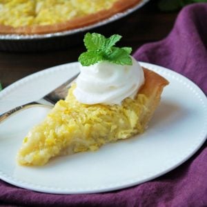 squash pie on a plate with whipped cream and fresh mint