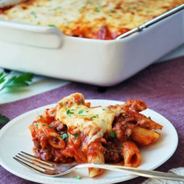 serving of baked mostaccioli with a fork and pan in the background