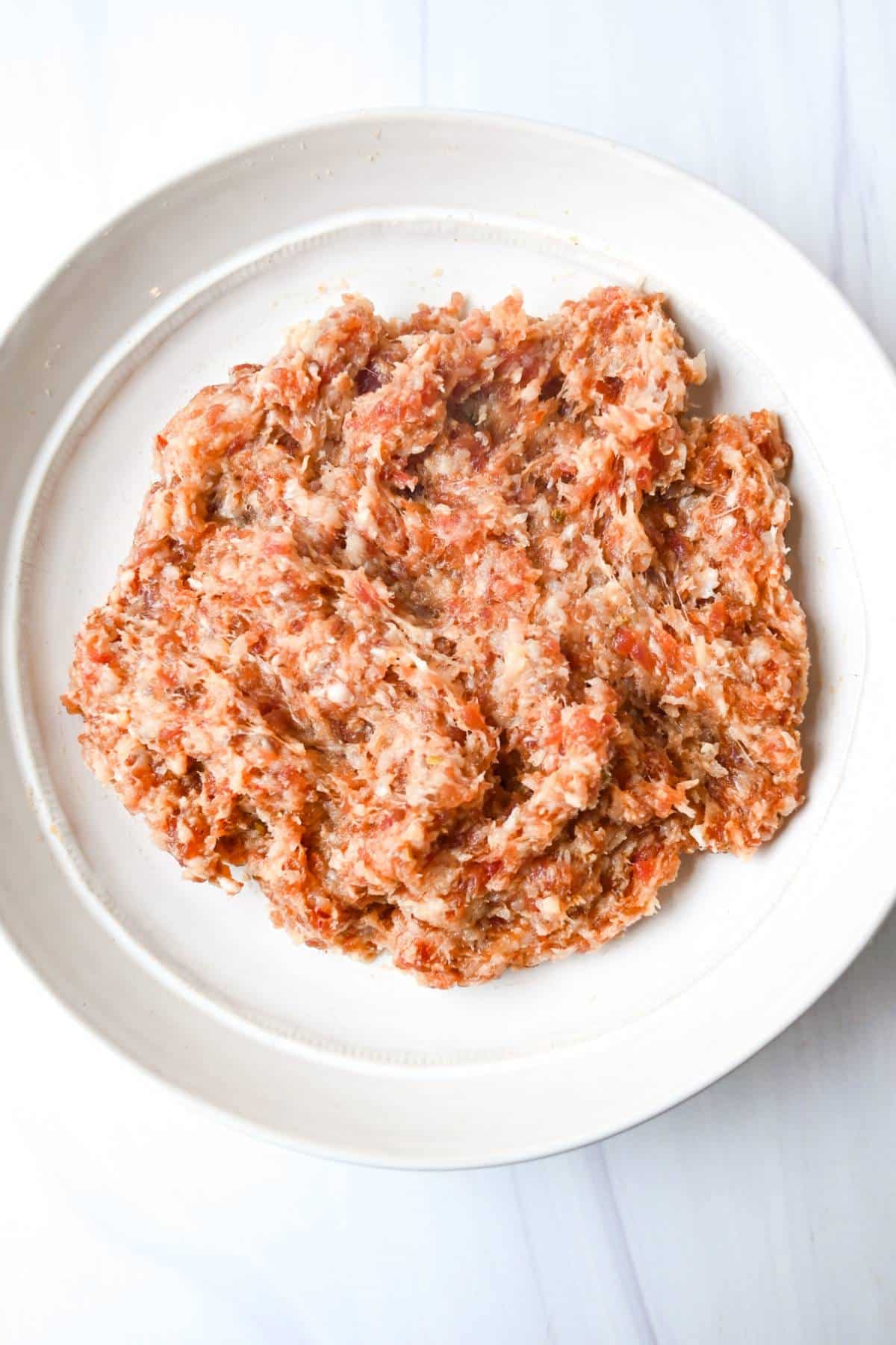 Italian sausage and ground chicken mixed in a bowl