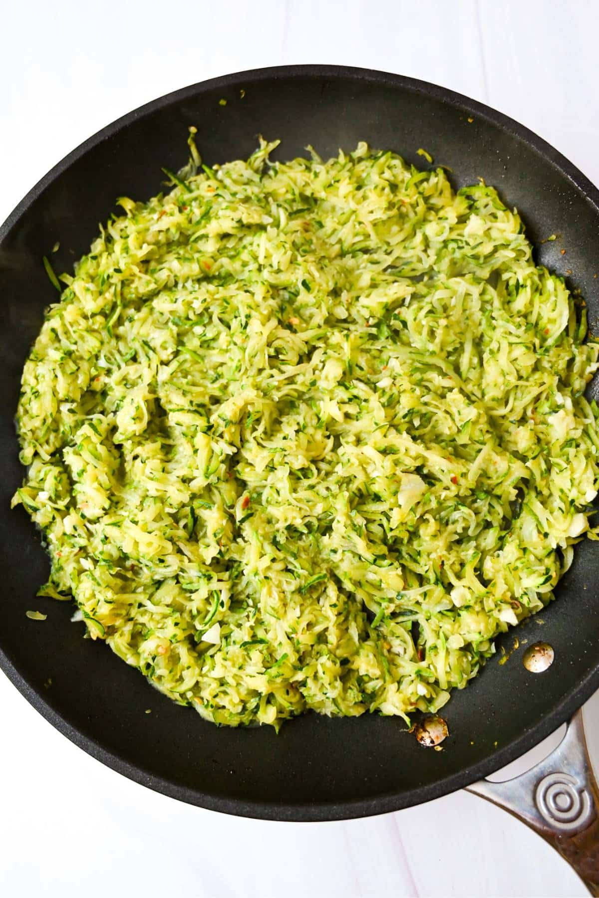 shredded zucchini and onion cooked in a skillet
