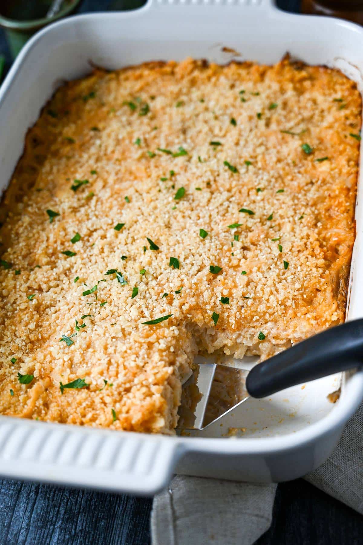hashbrown casserole hot from the oven with a serving cut out of it