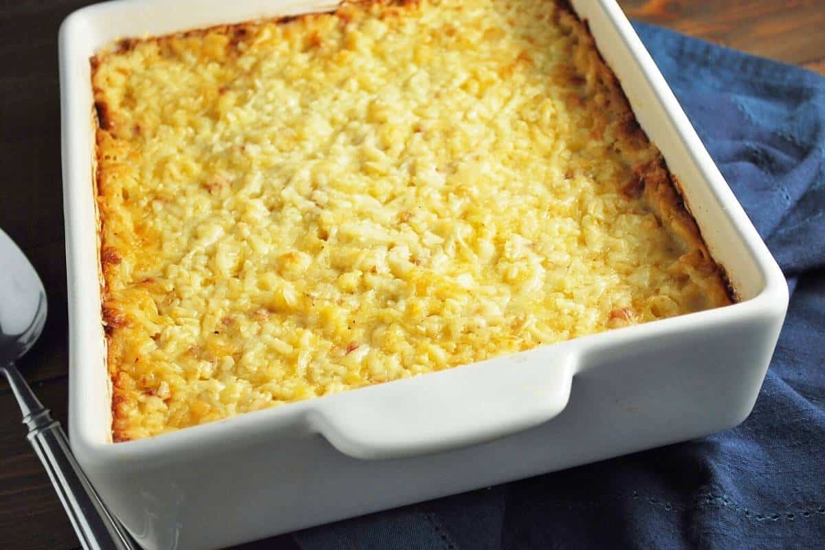 gluten free hashbrown casserole fresh from the oven with a serving spoon