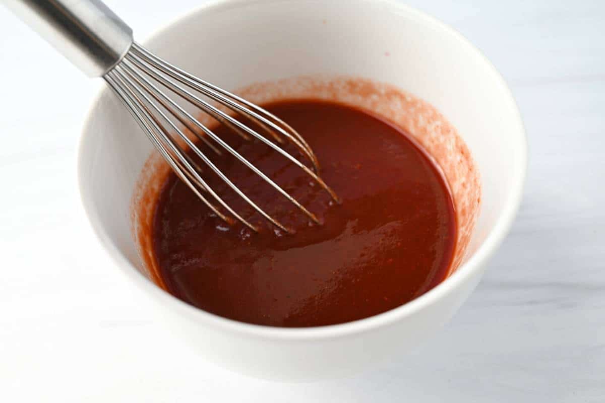 wine, worcestershire sauce, and tomato paste whisked in a bowl