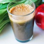 green power juice in a glass with an apple and bok choy