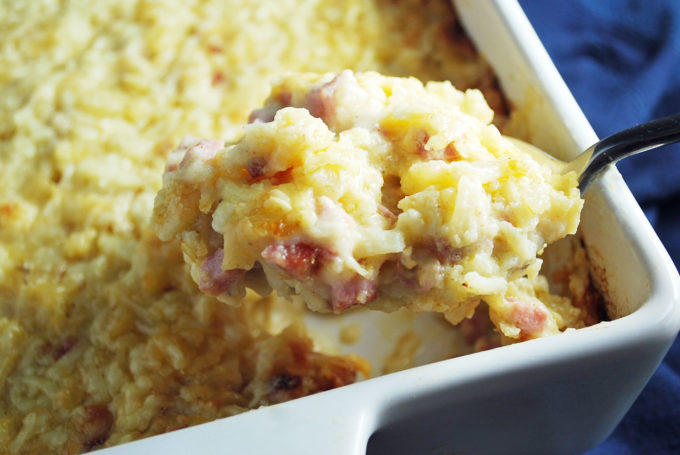 A serving of ham hashbrown casserole on a spoon