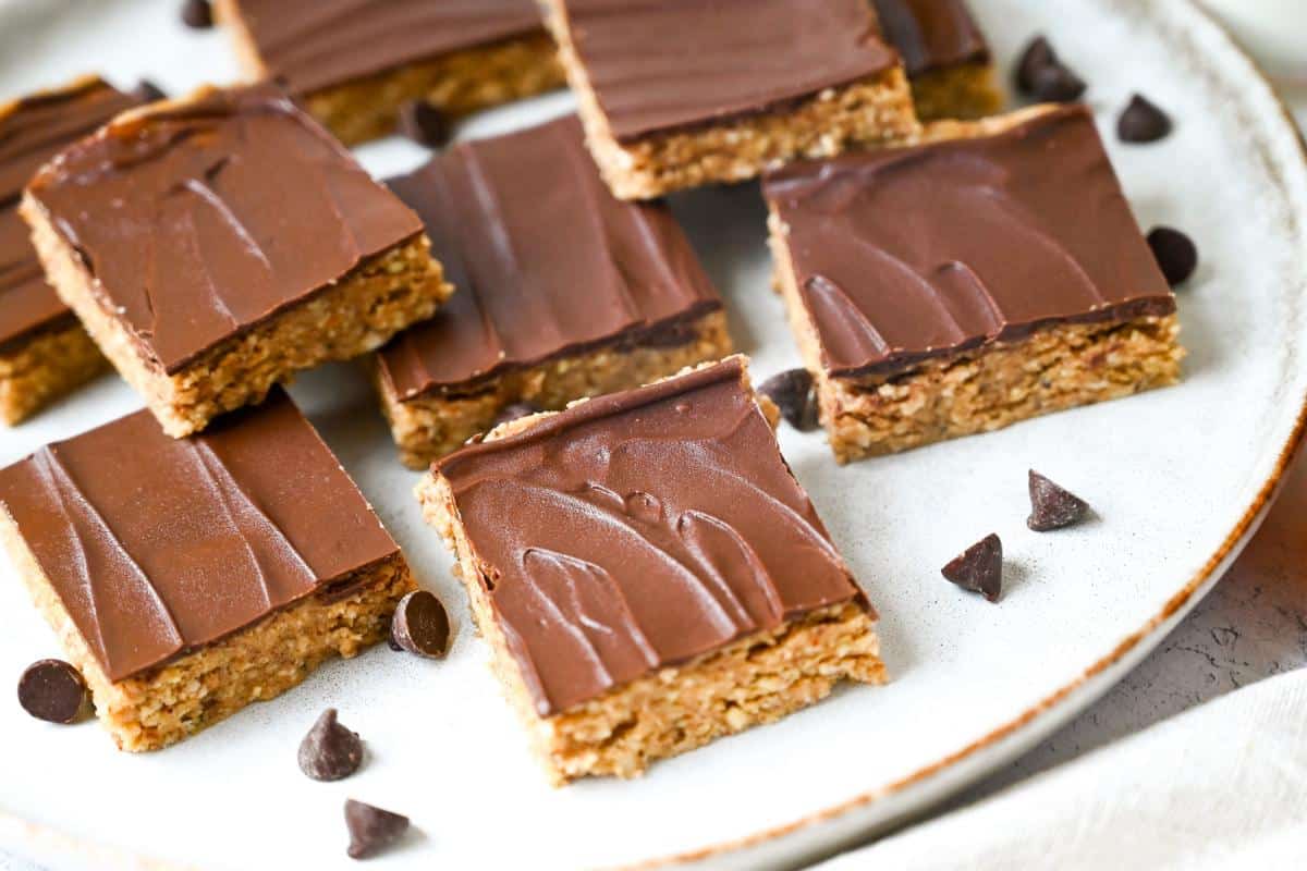 a plate of chocolate nutty bars with chocolate chips sprinkled around it