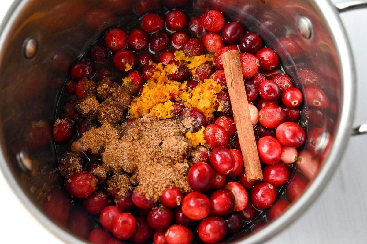 fresh cranberries, sugar, orange juice, orange zest, and cinnamon sticks in a saucepan