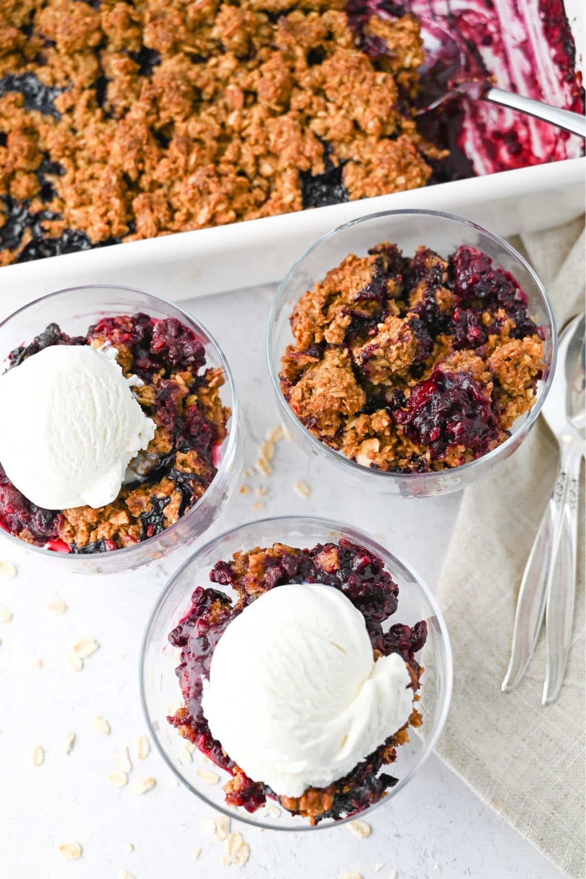 a pan of crumble with served up dishes with ice cream