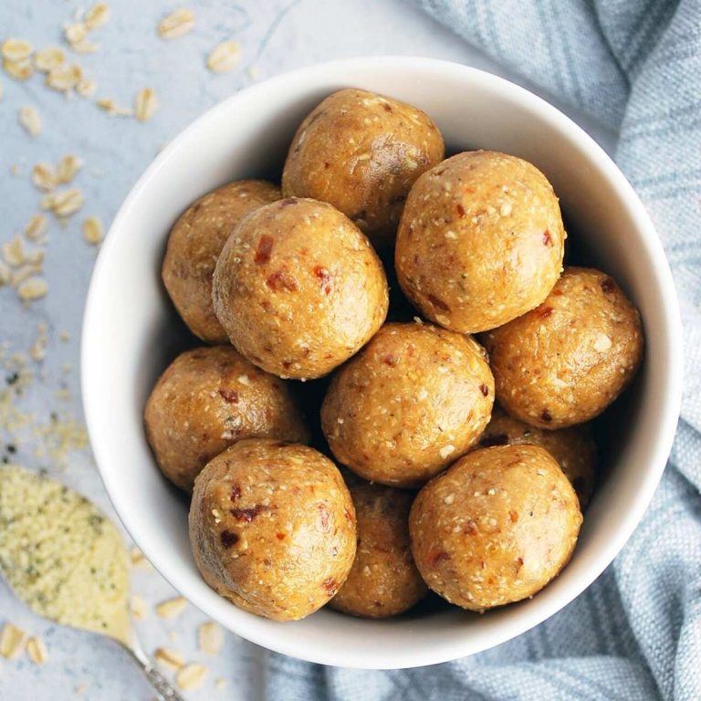 overhead photo of peanut butter protein balls with dates in a bowl with a spoon of hemp seeds on the side