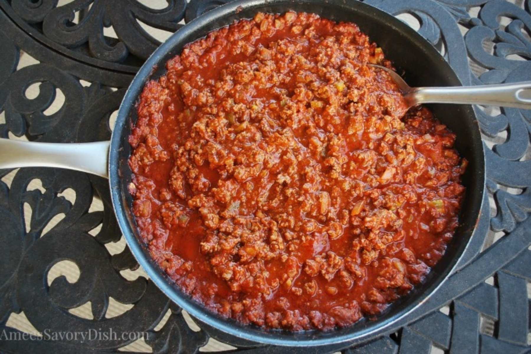 sloppy joes prepared in a skillet with a spoon