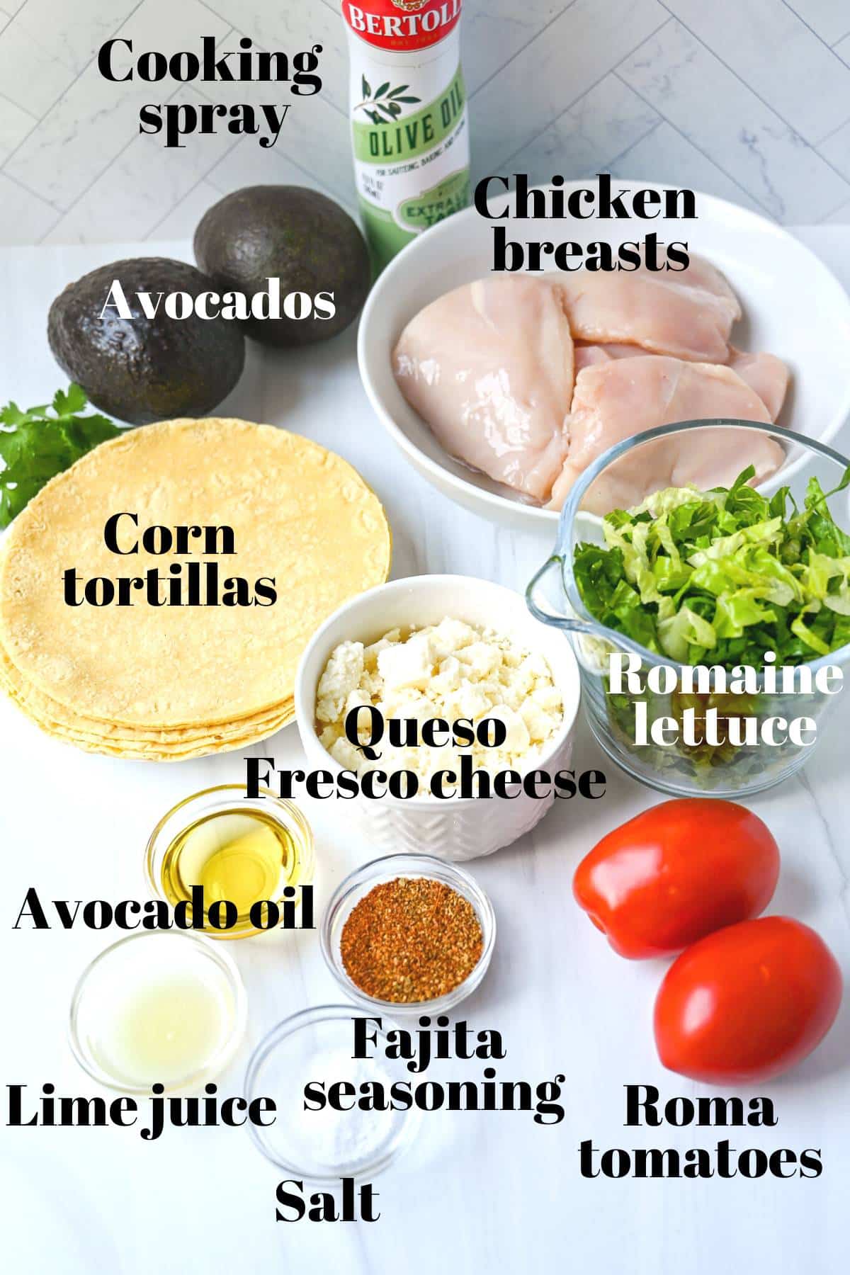 ingredients to make tostadas with mashed avocado, chicken, and toppings measured out on a counter