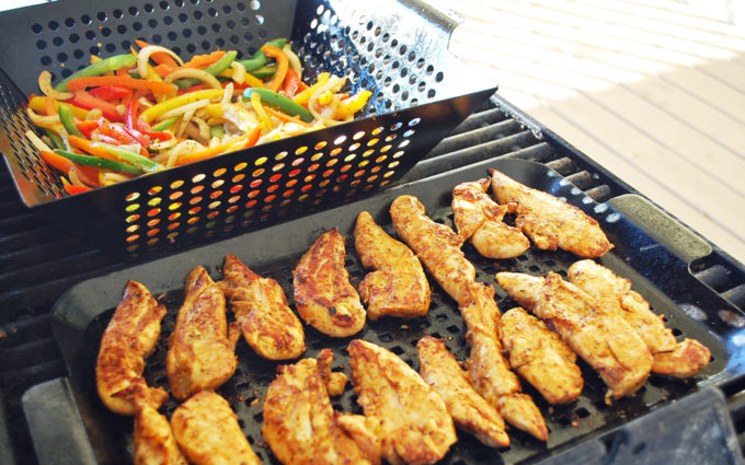 chicken tenders and vegetables on a grill