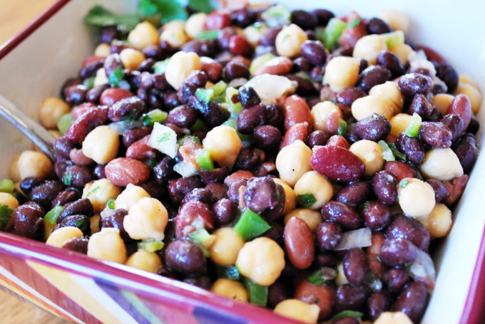 close up shot of bowl of Mexican bean salad with a spoon