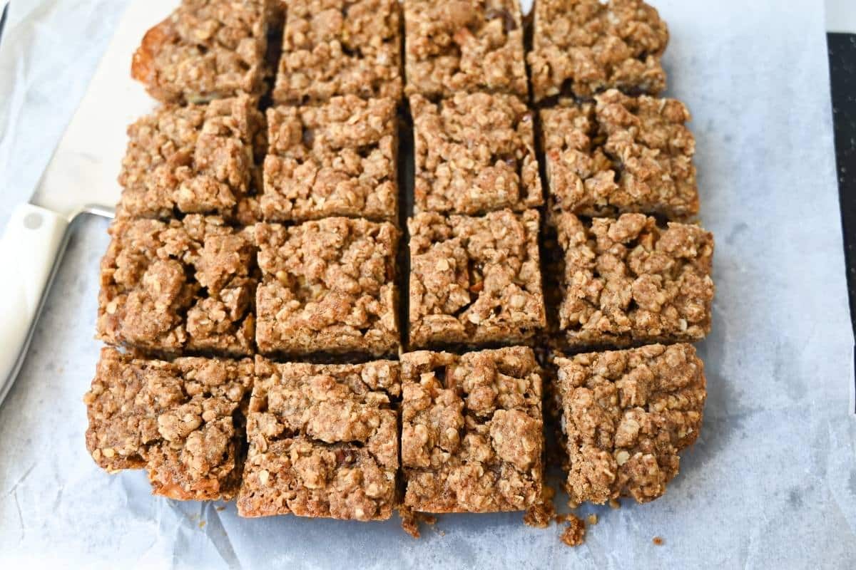 carmelita bars sliced into 16 squares on parchment paper