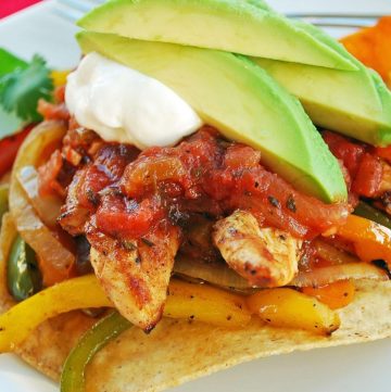 grilled chicken fajita tostada on a plate with avocado on top