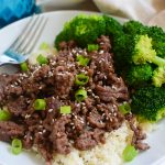 Korean beef over cauliflower rice on a plate with broccoli