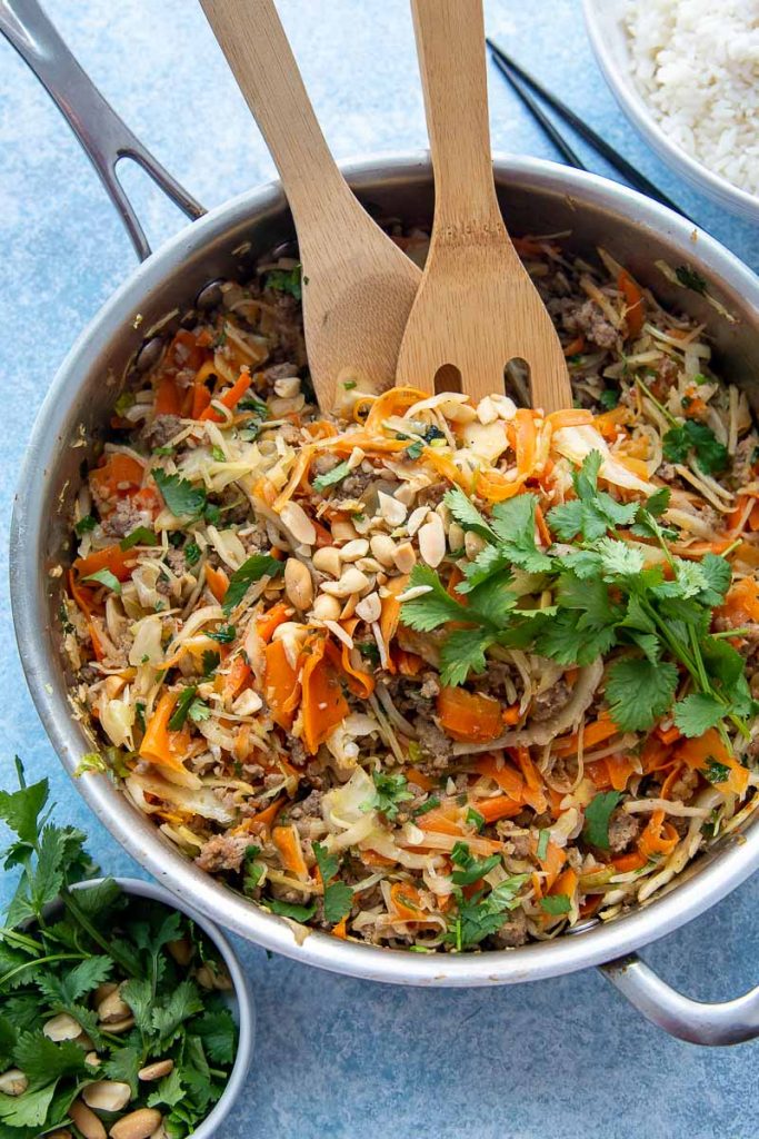 unstuffed egg roll in a skillet with wooden spoons