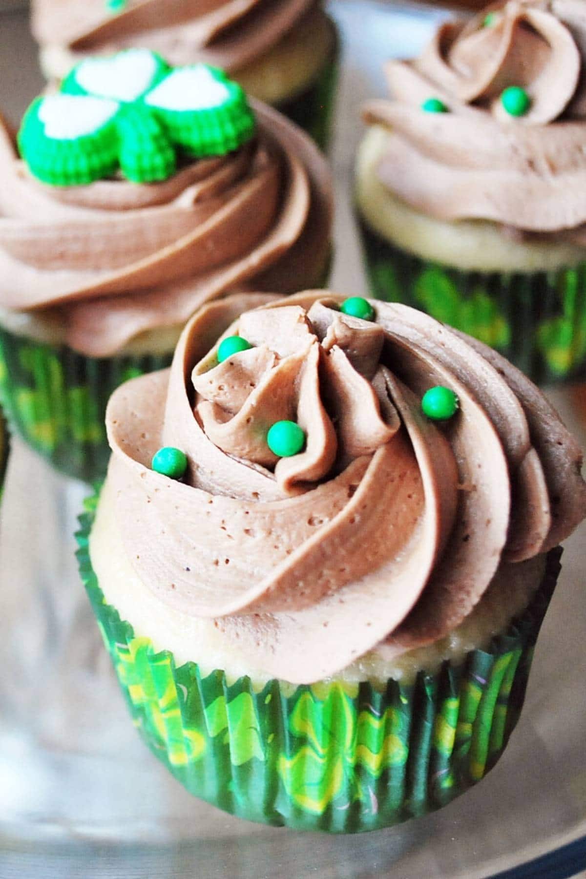 close up of Bailey's cupcakes topped with a swirl of mocha buttercream frosting and green sprinkles