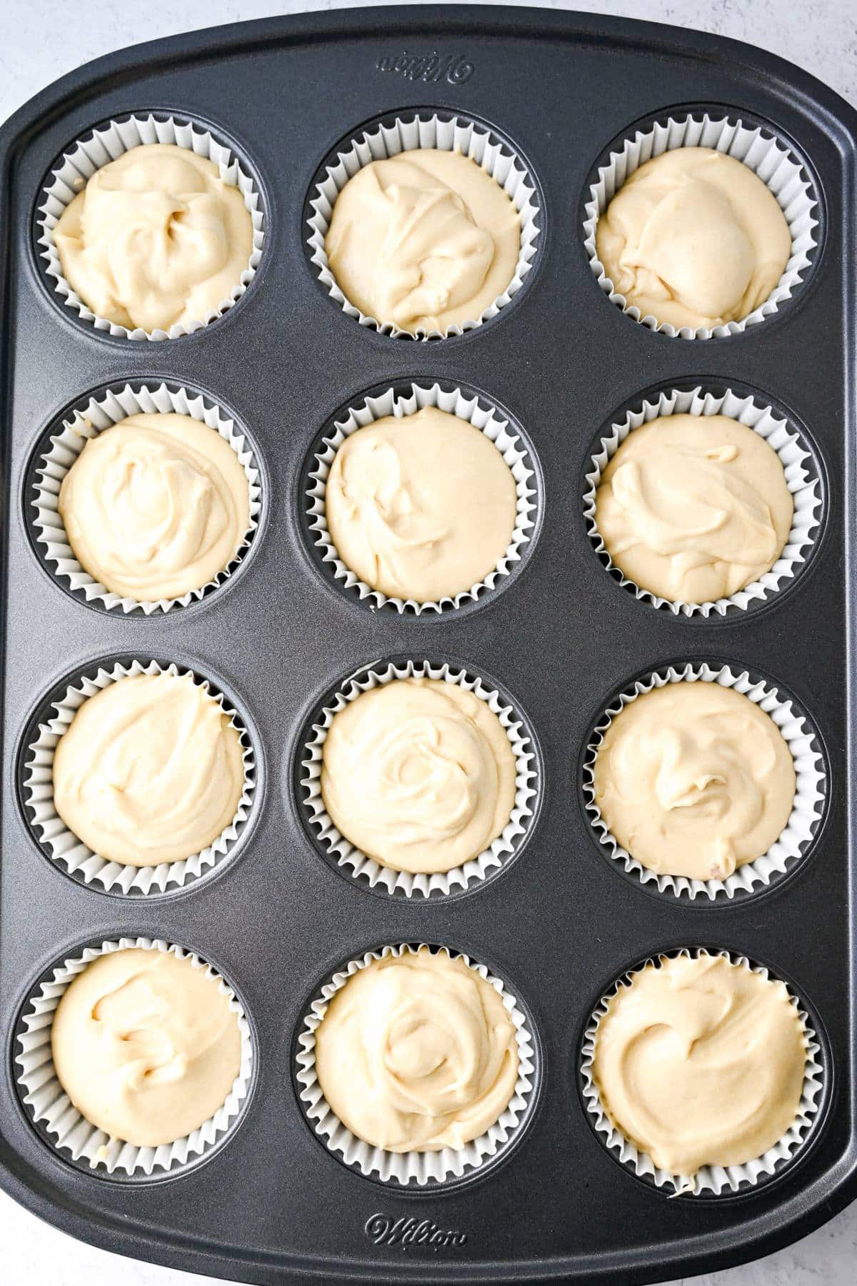 cupcake batter in liners in a muffin tin