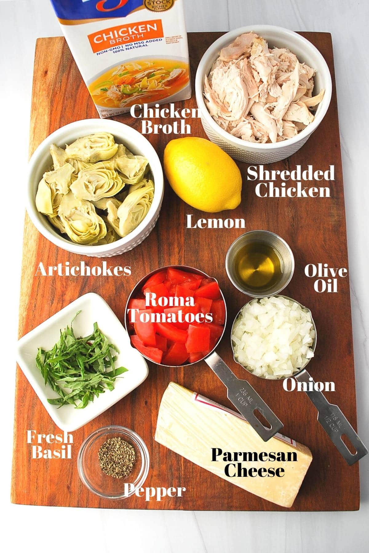 ingredients for chicken artichoke soup on a cutting board