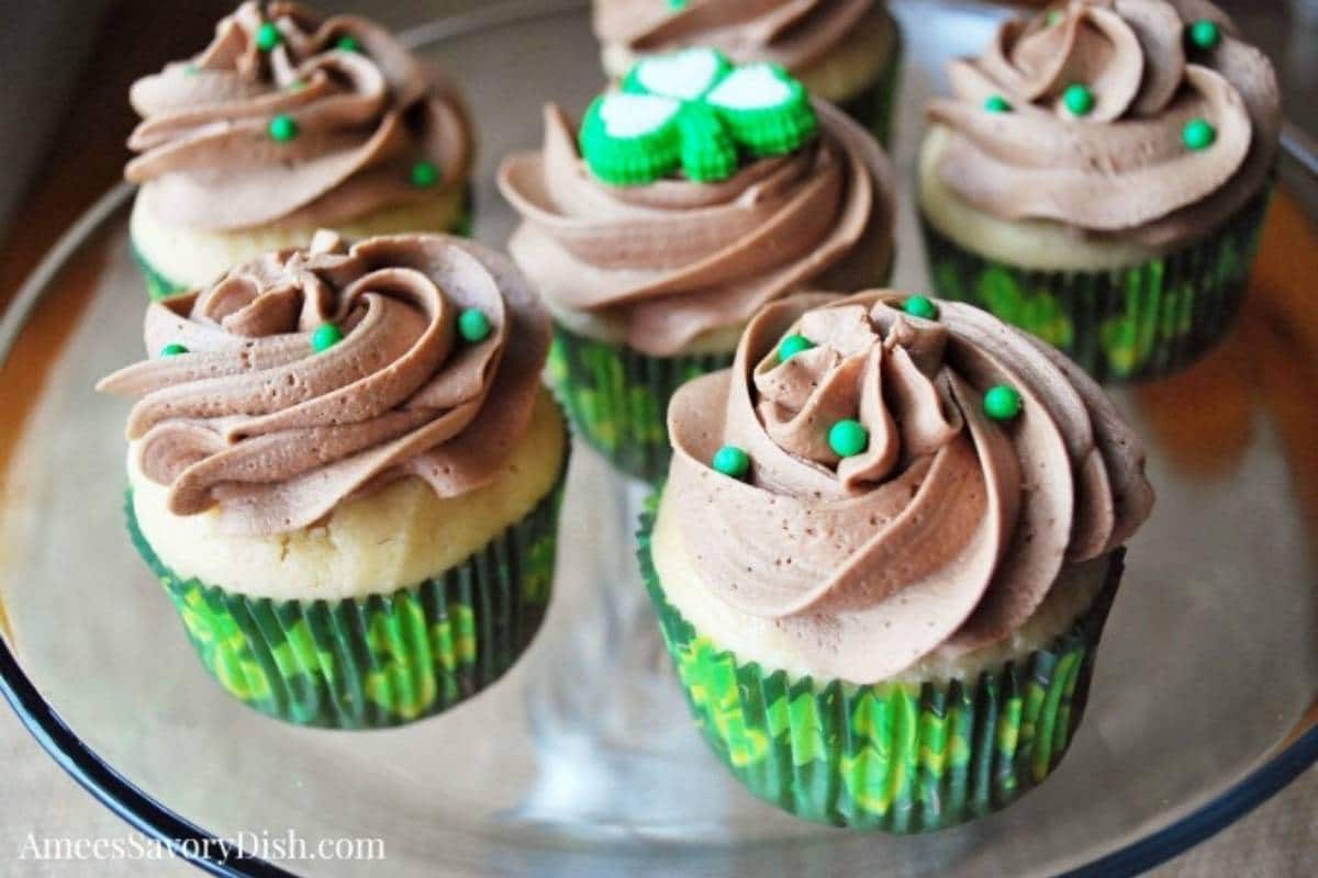 platter of baileys cupcakes in green shamrock liners with mocha frosting and green pearl sprinkles