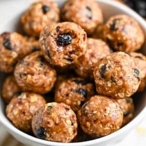 close up of a bowl of energy bites make with peanut butter and dried blueberries