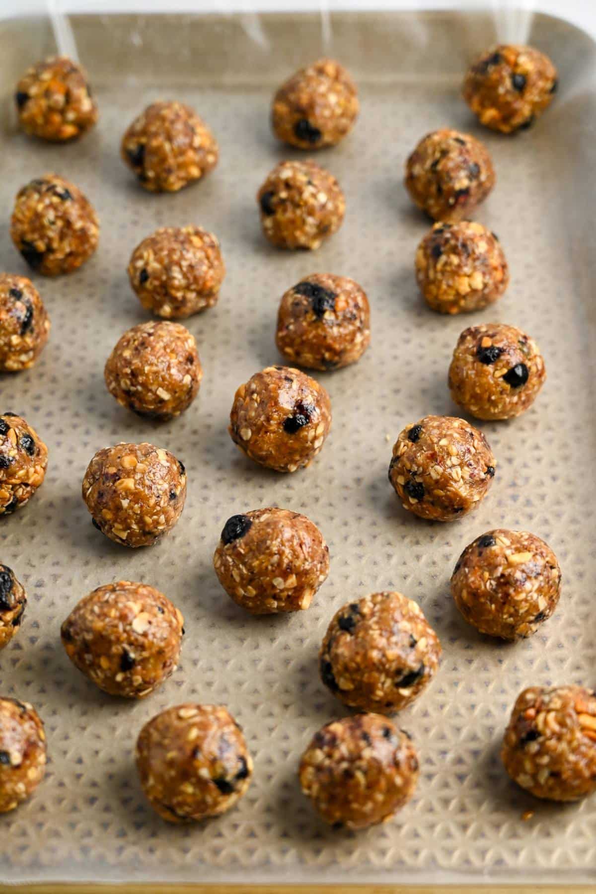 energy balls rolled on a wax paper lined baking sheet