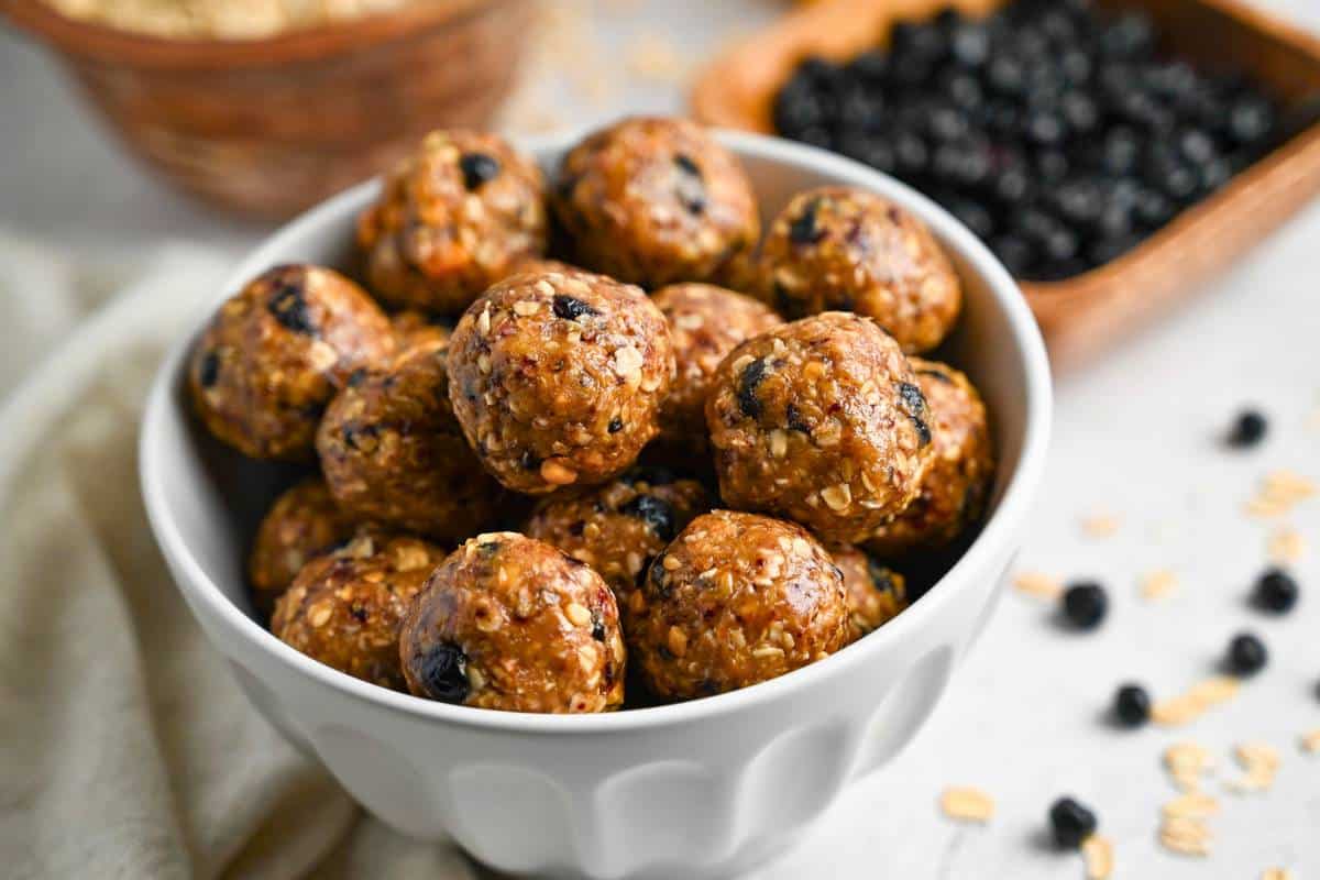 side view of a bowl of energy bites with dried blueberries