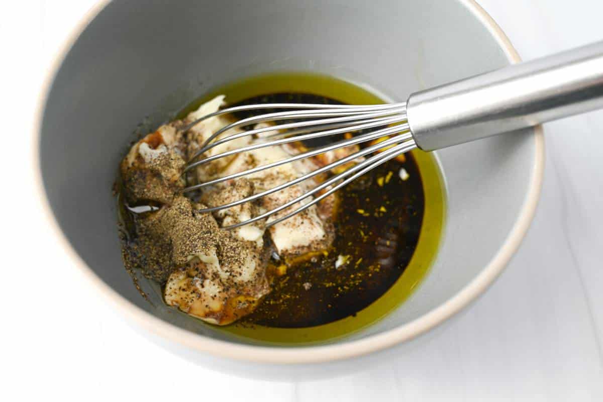 ingredients for creamy balsamic in a gray bowl with a whisk