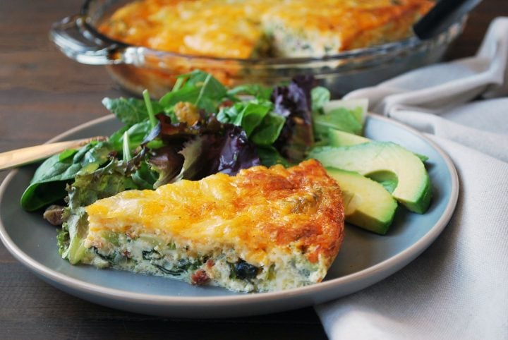 loaded quiche plated with salad and avocado