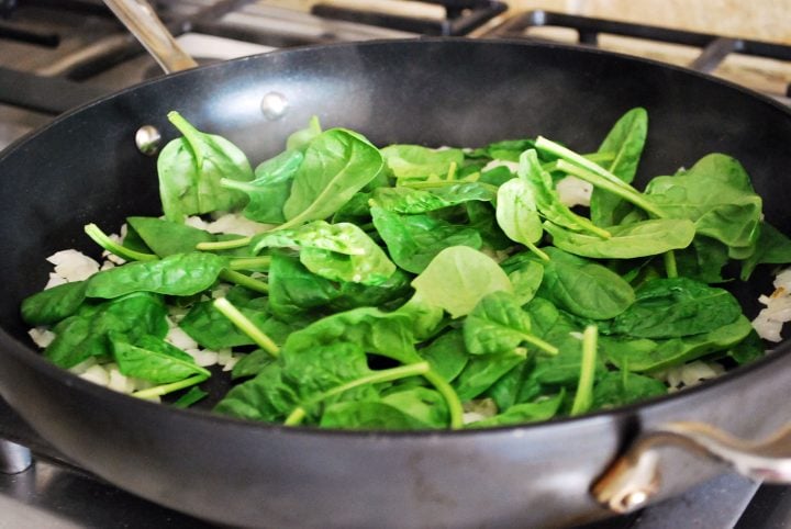 baby spinach cooking in pan for quiche