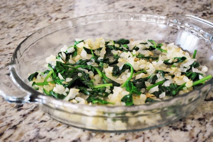 spinach mixture for quiche in a pie pan