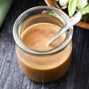 overhead photo of creamy balsamic salad dressing in a clear jar with a spoon
