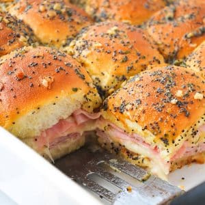 baked ham delight sandwiches in a pan with a small spatula