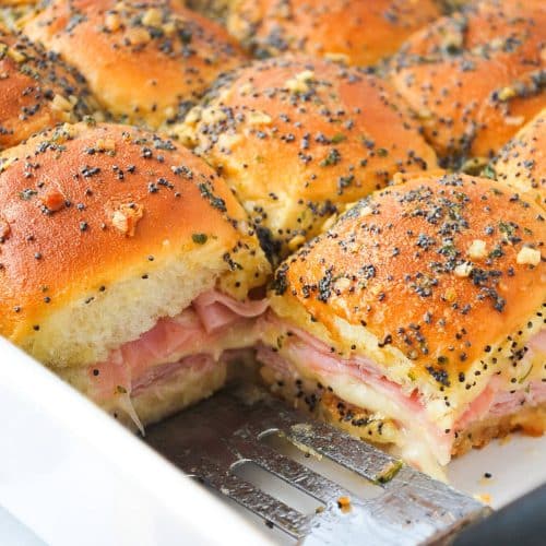 baked ham delight sandwiches in a pan with a small spatula