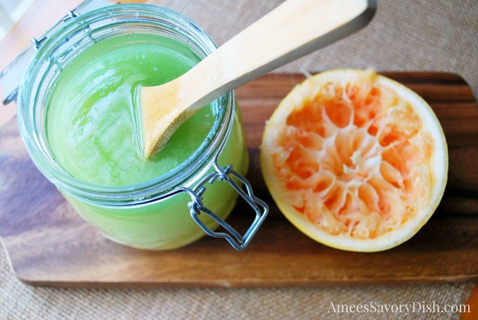 Sugar scrub in a jar and half a grapefruit on a wooden board