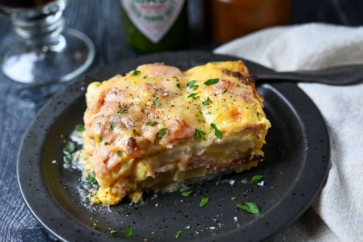 a slice of potato breakfast casserole on a plate with a fork