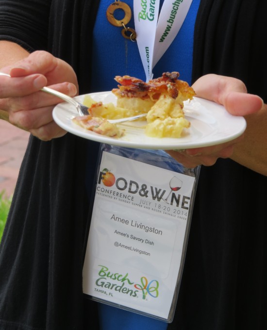 A woman holding a plate of Potato Casserole